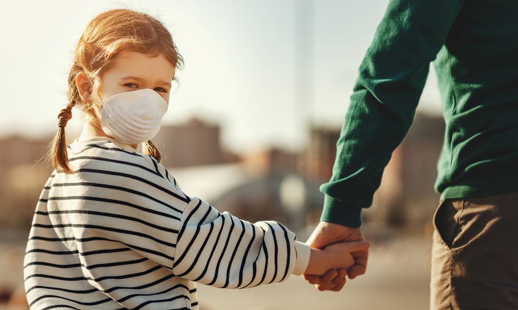 Little girl in medical mask holding hand of father